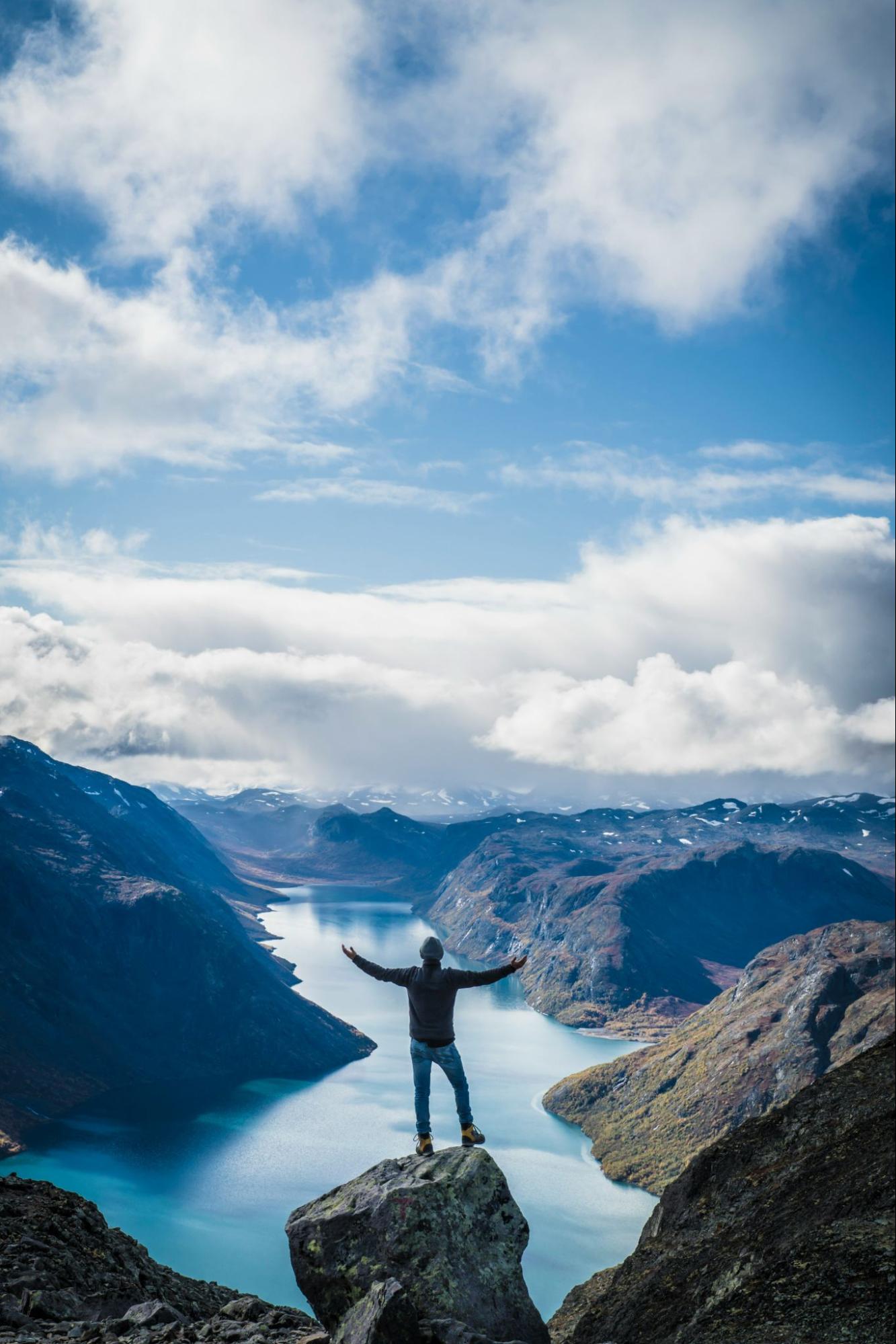 Man standing on mountain peak with arms outstretched
